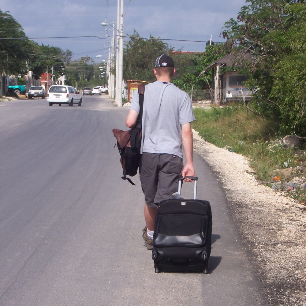 dragging a suitcase on a Mexican street